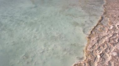 Transparent clear water in natural travertine pool close up.