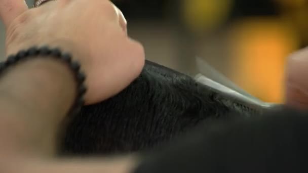 Peluquero masculino cortando el pelo de los clientes con una tijera de cerca. — Vídeo de stock