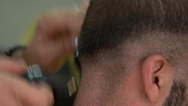 Professionell frisör gör frisyr för kunden med hjälp av elektrisk maskin och kam. — Stockvideo