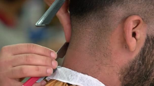 Close up hand of male barber shaving nape of customer with straight razor. — Stock videók