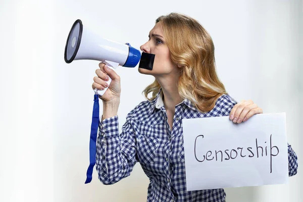 Vit kvinna protesterar med megafon och tejp över munnen oförmögen att tala ut. — Stockfoto