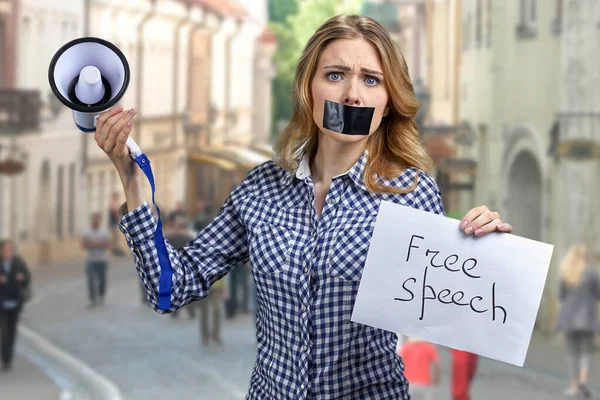 Vrouw demonstrant met getapete mond met spandoek met opschrift Vrijheid van meningsuiting. — Stockfoto