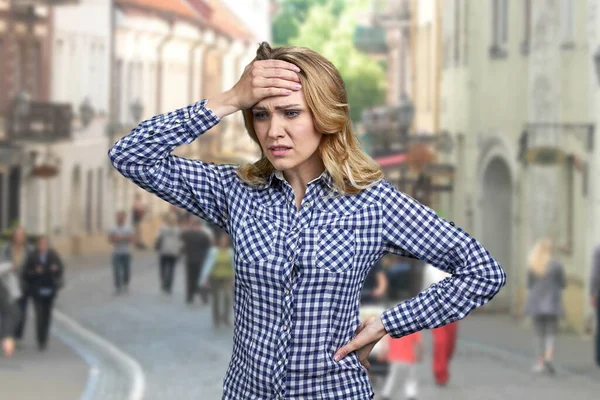 Молодая обеспокоенная женщина, стоящая на размытой улице города. — стоковое фото