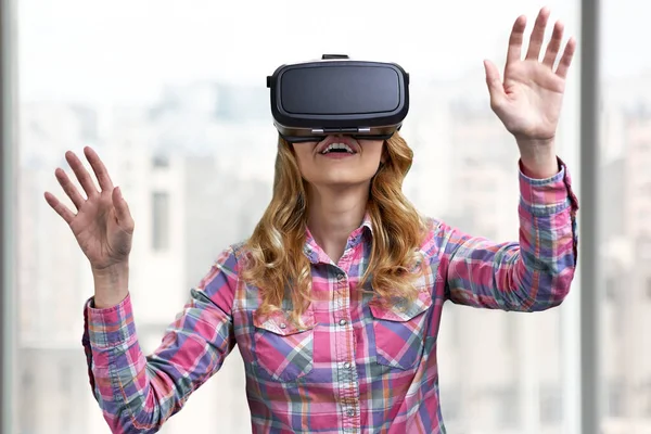 Ragazza eccitata utilizzando cuffia realtà virtuale su sfondo sfocato. — Foto Stock