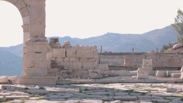Археологические руины каменной арки, ступени, колонны и стены. — стоковое видео