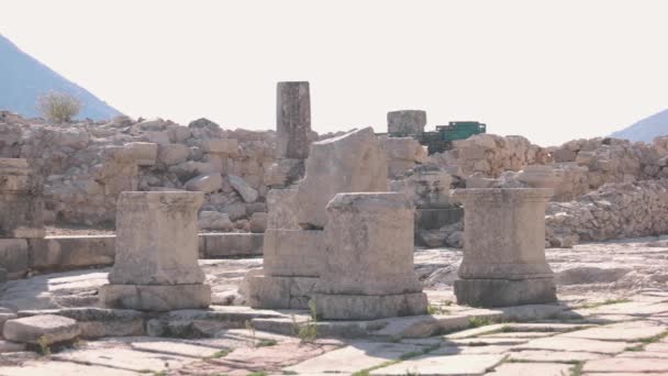Ruiny archeologiczne starożytnego budynku. Pozostałości łuku kamiennego, ściany i słupów. — Wideo stockowe