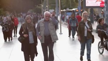 Bir yaz günü şehir caddesinde yürüyen bir kalabalık..