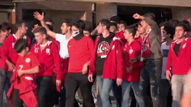 Attivisti maschi in maglioni rossi alzano i pugni mentre camminano per strada. — Video Stock