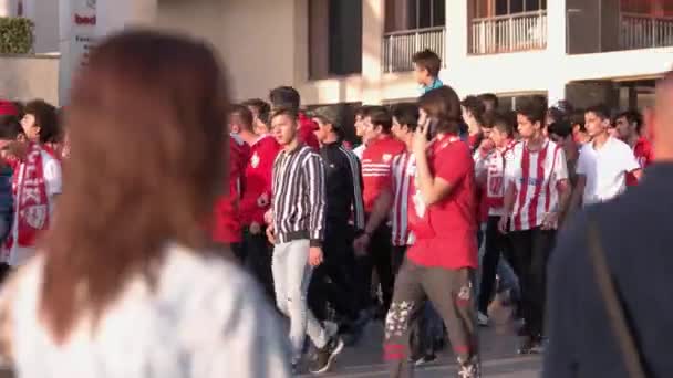 Футбольные болельщики прогуливаются по городской улице. Молодые футбольные болельщики. — стоковое видео