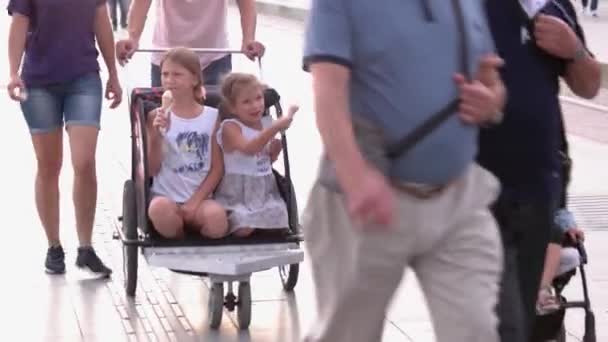 Personer med barnvagnar går på stadens gata en sommardag. — Stockvideo