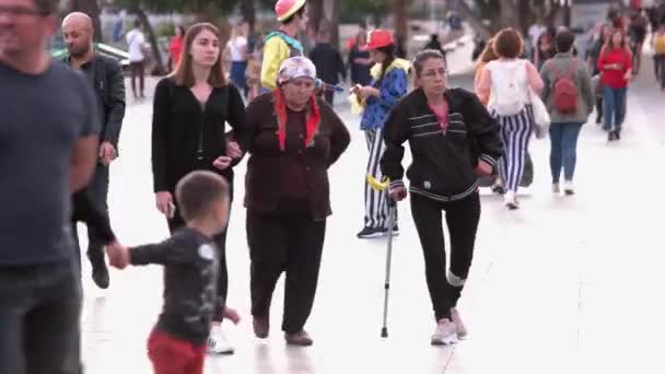 Vrouw met gewond been loopt met stok langs de straat van de stad. — Stockvideo