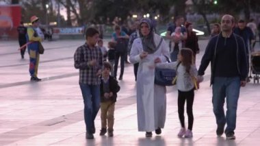 Kalabalık bir caddede çocuklarıyla yürüyen Müslüman çift..