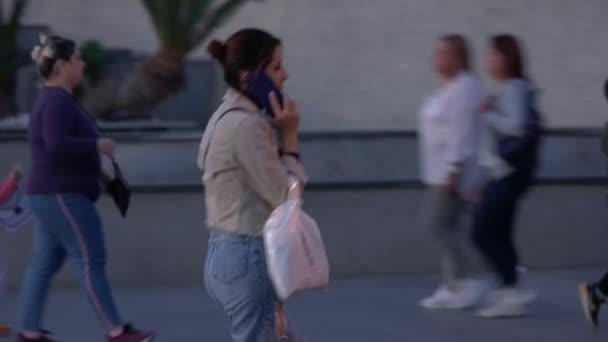 都会の通りを歩きながら携帯電話で話す若いスタイリッシュな女性のスローモーション. — ストック動画