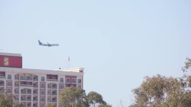 Avião sobrevoando a cidade em céu azul claro da manhã. — Vídeo de Stock