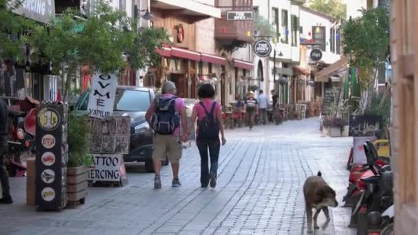 Urban scene with tourists on narrow cobbled street and architecture of old town. — Stock Video