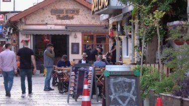 Eski kasabadaki dar bir kaldırım taşı sokakta yürüyen insanlar..