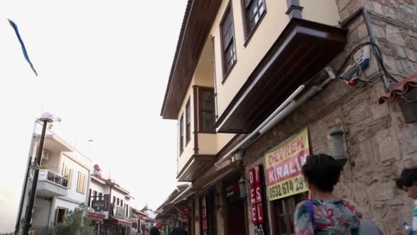 Smalle geplaveide straat met gevels van gebouwen. Toeristen en outdoor cafe van toeristische stad. — Stockvideo