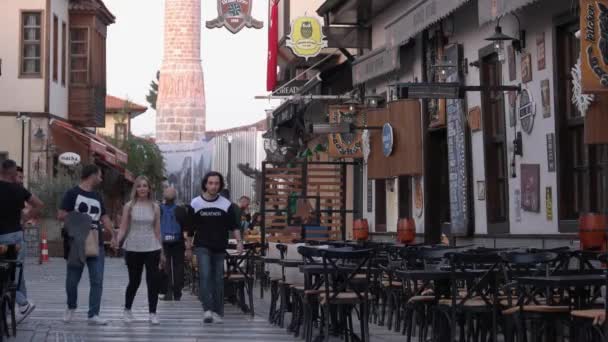 Столы кафе на узкой мощеной улице. Башня мечети на заднем плане, Турция. — стоковое видео