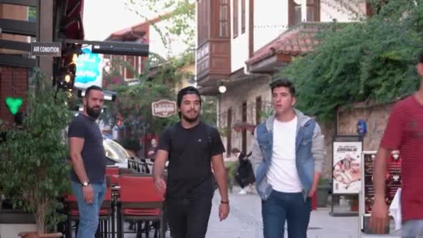 De jeunes hommes marchant dans la rue de la ville turque. Beaux bâtiments en arrière-plan. — Video