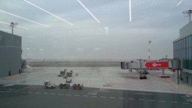 Havaalanı terminalinde hızlı hareket eden araçlar. Pencereden görüntüle.