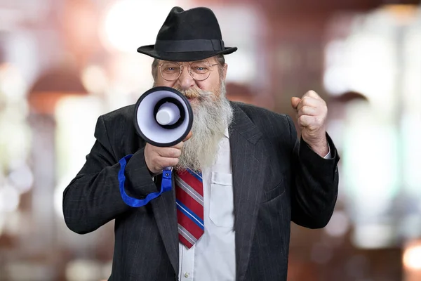 Senior man politiker talar in i megafon och håller sin näve knuten. — Stockfoto