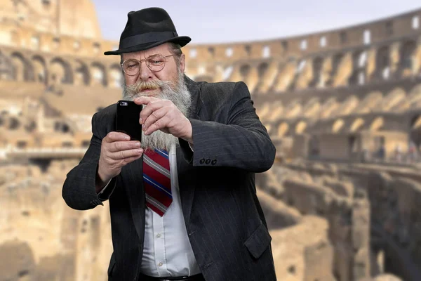 Staruszek turysta robi zdjęcie swoim smartfonem. — Zdjęcie stockowe