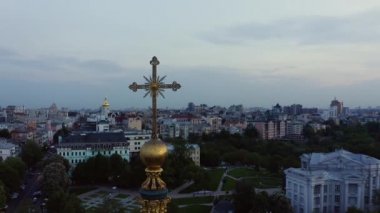 Şehir manzaralı altın kilise haçı.