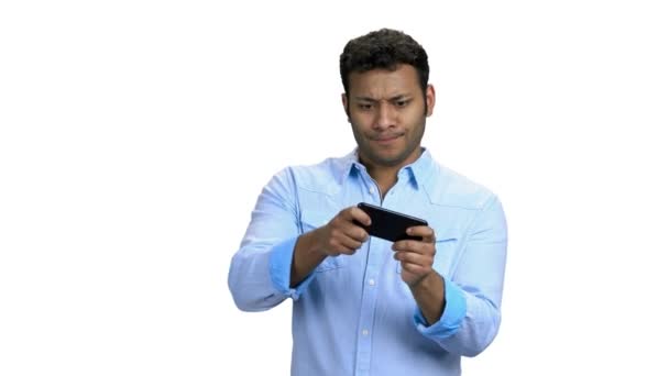 Jonge geconcentreerde man spelende game op smartphone. — Stockvideo