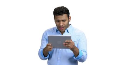 Beyaz arka planda tablet tablet kullanan neşeli Hintli adam.