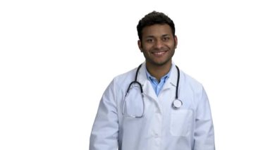 Genç gülümseyen doktor hapları gösteriyor ve başparmağını kaldırıyor..