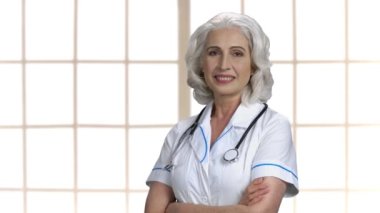 Kameraya bakan olgun bir doktorun portresi.