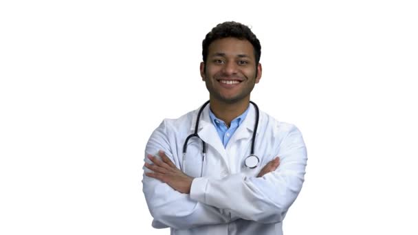 Happy young doctor crossed arms on white background. — Stock Video