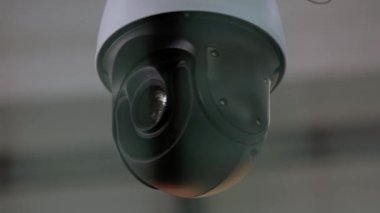Close-up of surveillance video camera rotating around.