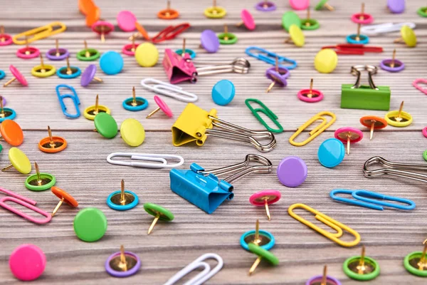 Set of various colorful paper clips on wooden desk. — Stockfoto