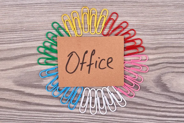 Top view office word and many colored paperclips. — Fotografia de Stock