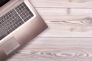 Laptop bilgisayarı ve çiçekli gri ofis masası.