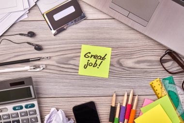 Üst görünüm düz ofis eşyaları ve harika bir iş yazısıyla yapışkan not..