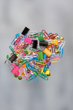 Mavili arkaplanda çeşitli ataç yığınları.