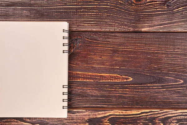 Top view flat lay blank notepad on a brown wooden surface. — Stok fotoğraf