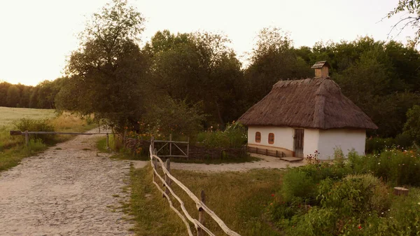 Mały ładny dom otoczony prostym drewnianym ogrodzeniem na wsi. — Zdjęcie stockowe