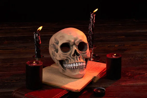 Halloween összetétele kísérteties emberi koponya égő gyertyákkal. — Stock Fotó