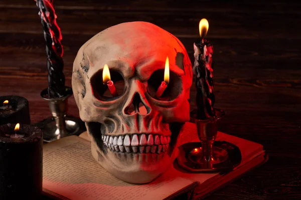 Composição de velas acesas no crânio humano antigo. — Fotografia de Stock