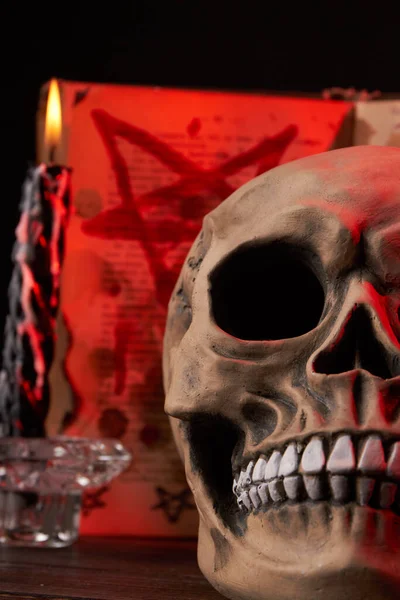 Close-up vertical shot humans skull and burning wax candle. — Stock Photo, Image