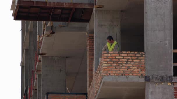 Trabalhador da construção esfregaços concrente líquido sobre tijolo costuras nível. — Vídeo de Stock