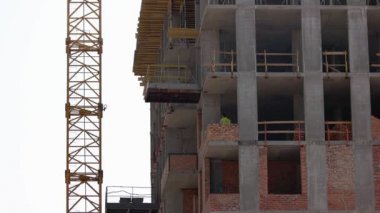 Binadaki işçiler tuğlalara çimento bulaştırıyor..