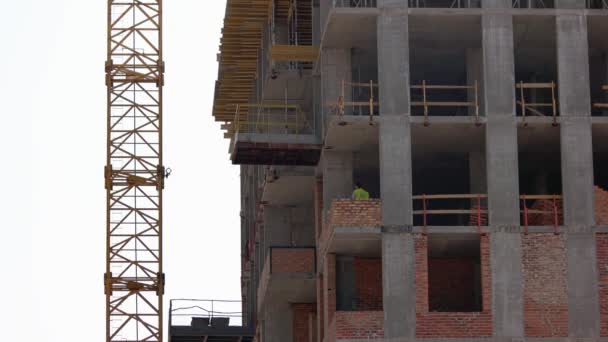 Dělník v budově rozmazává beton po cihlách. — Stock video