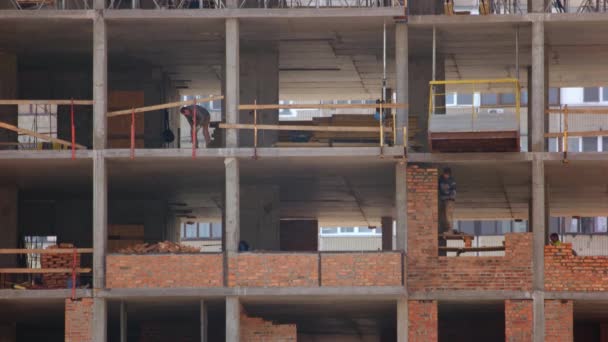 Rascacielos trabajadores de la construcción de edificios en diferentes habitaciones. — Vídeo de stock