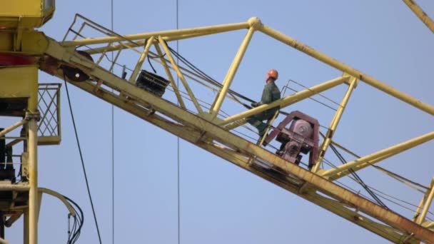 Construtor de trabalhadores de construção senta-se no guindaste amarelo. — Vídeo de Stock