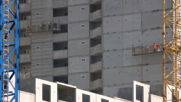 Bouw wolkenkrabber gebouw met arbeiders en kranen. — Stockvideo