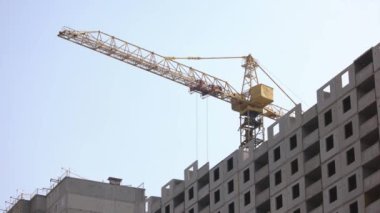 Binanın üzerinde yüksek sarı vinç var..
